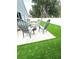 This backyard features artificial turf, an outdoor seating area, and a white privacy fence at 4339 Northern Dancer Way, Orlando, FL 32826