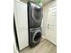 Modern laundry setup with stacked washer and dryer, plus storage at 4339 Northern Dancer Way, Orlando, FL 32826