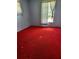 Bedroom with bright red carpet, white walls, and a window offering natural light at 461 Marigold Rd, Casselberry, FL 32707