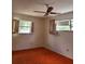 Spacious bedroom featuring dual windows, an overhead fan, and dated carpet in need of updating or replacement at 461 Marigold Rd, Casselberry, FL 32707