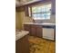 Outdated kitchen with wood cabinets, double sink, a window and a dishwasher at 461 Marigold Rd, Casselberry, FL 32707
