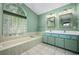 Ensuite bathroom features double sinks, tub, and glass block window at 5097 Nw 19Th Pl, Ocala, FL 34482