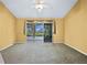 Comfortable carpeted living room with sliding glass doors, offering easy access to the outdoor area at 5097 Nw 19Th Pl, Ocala, FL 34482