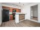 Kitchen with wood cabinets, black appliances, and wood-look flooring at 510 E Wisconsin Ave, Orange City, FL 32763