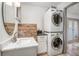 Updated laundry room with white vanity and stacked washer and dryer at 510 E Wisconsin Ave, Orange City, FL 32763