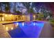 Backyard view featuring a sparkling in-ground pool and outdoor dining area at dusk at 510 E Wisconsin Ave, Orange City, FL 32763
