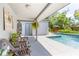 Covered patio leading to a stunning pool with lounge furniture, surrounded by lush landscaping at 510 E Wisconsin Ave, Orange City, FL 32763