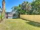 The grassy backyard with a newly installed wooden fence and screened-in pool provides outdoor enjoyment at 5400 Turton Ln, Port Orange, FL 32127