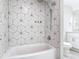 This bathroom features a white tub with unique, geometric tile and chrome fixtures at 5400 Turton Ln, Port Orange, FL 32127