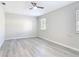 This bedroom features light gray walls, a ceiling fan, a window, and modern gray vinyl flooring at 5400 Turton Ln, Port Orange, FL 32127