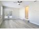 This bonus room features light gray walls, a ceiling fan, doors to the pool, and modern gray vinyl flooring at 5400 Turton Ln, Port Orange, FL 32127