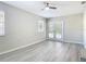 This bonus room features light gray walls, a ceiling fan, doors to the pool, and modern gray vinyl flooring at 5400 Turton Ln, Port Orange, FL 32127