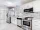 Modern kitchen featuring white cabinets, stainless appliances, and stylish geometric backsplash at 5400 Turton Ln, Port Orange, FL 32127