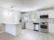 Modern kitchen featuring white cabinets, stainless appliances, and stylish geometric backsplash at 5400 Turton Ln, Port Orange, FL 32127