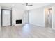 Bright living room featuring whitewashed fireplace, wood-look floors, and modern ceiling fan at 5400 Turton Ln, Port Orange, FL 32127