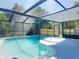 Sparkling backyard pool surrounded by a screened enclosure and lush landscaping at 5400 Turton Ln, Port Orange, FL 32127