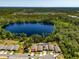 Aerial view of the property showcasing its location on a lake with surrounding trees and nearby houses at 6006 Mount Zion Cir, Deland, FL 32724