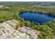 Aerial view of the home near a lake, surrounded by trees, and in a residential neighborhood at 6006 Mount Zion Cir, Deland, FL 32724