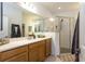 Bright bathroom features double vanity, a large mirror, and a glass-enclosed shower with stone flooring at 6006 Mount Zion Cir, Deland, FL 32724