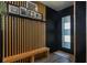Modern entryway featuring black walls, a light wood slat wall, and a matching wood bench at 6006 Mount Zion Cir, Deland, FL 32724