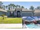 Beautiful single-Gathering home features a two-car garage, lawn, flowerbeds, and a screened-in pool at 6006 Mount Zion Cir, Deland, FL 32724