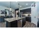 Well-lit kitchen featuring a large island with seating, modern dark cabinetry, and stainless steel appliances at 6006 Mount Zion Cir, Deland, FL 32724