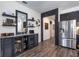 Modern kitchen with stainless steel refrigerator, bar with a beverage fridge and open shelving at 6006 Mount Zion Cir, Deland, FL 32724