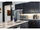 Close-up of a kitchen island with granite countertop, dark cabinets, and stainless steel appliances at 6006 Mount Zion Cir, Deland, FL 32724