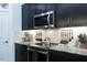 Modern kitchen features sleek black cabinetry, stainless steel appliances, and a stylish subway tile backsplash at 6006 Mount Zion Cir, Deland, FL 32724
