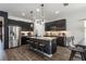 Open kitchen showcases a large island with barstools, sleek dark cabinets, and stainless steel appliances at 6006 Mount Zion Cir, Deland, FL 32724