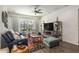 Comfortable living room features stylish decor, large windows, a floral rug, and media center at 6006 Mount Zion Cir, Deland, FL 32724