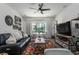Cozy living room features large window, a comfortable leather sofa, and a stylish floral rug at 6006 Mount Zion Cir, Deland, FL 32724