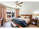 Cozy bedroom features a wooden bed frame, soft lighting, and a view to the screened in lanai at 6006 Mount Zion Cir, Deland, FL 32724
