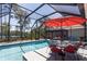 Inviting screened pool area with lake view, outdoor seating, and an umbrella-covered table at 6006 Mount Zion Cir, Deland, FL 32724