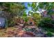 Charming backyard with brick pathway, lush landscaping, and a cozy fire pit area, perfect for outdoor relaxation at 605 Goodall Ave, Daytona Beach, FL 32118