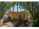 Side exterior of home with wooden fence, small deck area and mature trees offering ample shade and privacy at 605 Goodall Ave, Daytona Beach, FL 32118