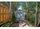 Exterior shot of a detached garage with a white door, surrounded by lush greenery, offering parking and storage at 605 Goodall Ave, Daytona Beach, FL 32118