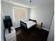 Cozy bedroom featuring a bed, dark wood floors, and a window at 606 W Voorhis Ave, Deland, FL 32720