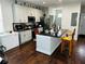 Spacious kitchen with white cabinetry, black countertops, stainless steel appliances, and a convenient island at 606 W Voorhis Ave, Deland, FL 32720