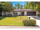 Well-maintained one-story home featuring a black roof, two-car garage, and beautiful landscaping at 639 Elwood St, Deltona, FL 32725