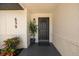 Welcoming front porch with a black front door, adorned with stylish plants and modern lighting fixtures at 639 Elwood St, Deltona, FL 32725