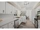 Spacious kitchen featuring white cabinets, stainless steel appliances, and views into the dining room at 639 Elwood St, Deltona, FL 32725