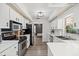 Modern kitchen with white countertops, black appliances, and view into a sitting room at 639 Elwood St, Deltona, FL 32725