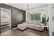 Cozy living room featuring a grey accent wall, hardwood flooring, and a comfortable grey couch at 639 Elwood St, Deltona, FL 32725