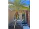 Close-up of the front door entrance, framed by a palm tree and featuring a modern glass door at 670 W Tall Pine Ter, Deland, FL 32724