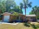 Inviting single-story home with palm trees and a well-maintained front yard under a clear blue sky at 670 W Tall Pine Ter, Deland, FL 32724