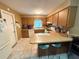 Functional kitchen featuring wood cabinets, tile floors, and a breakfast bar with seating at 670 W Tall Pine Ter, Deland, FL 32724