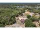 Aerial view showing a house, horse paddock, and pond nestled among lush greenery with a lake in the background at 685 Enterprise Osteen Rd, Osteen, FL 32764