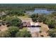 An aerial view showcases the home, with a carport, on a large wooded lot near a lake at 685 Enterprise Osteen Rd, Osteen, FL 32764