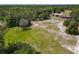 Aerial view of a spacious property showcasing green lawns, mature trees, and a house with a pool at 685 Enterprise Osteen Rd, Osteen, FL 32764
